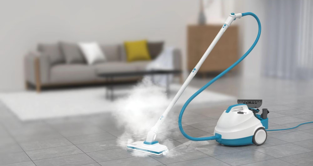 Un nettoyeur vapeur nettoyant un sol carrelé gris, arrière-plan flou.