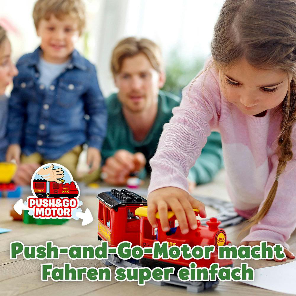 Kind, das mit roter Spielzeugeisenbahn mit Familie spielt.
