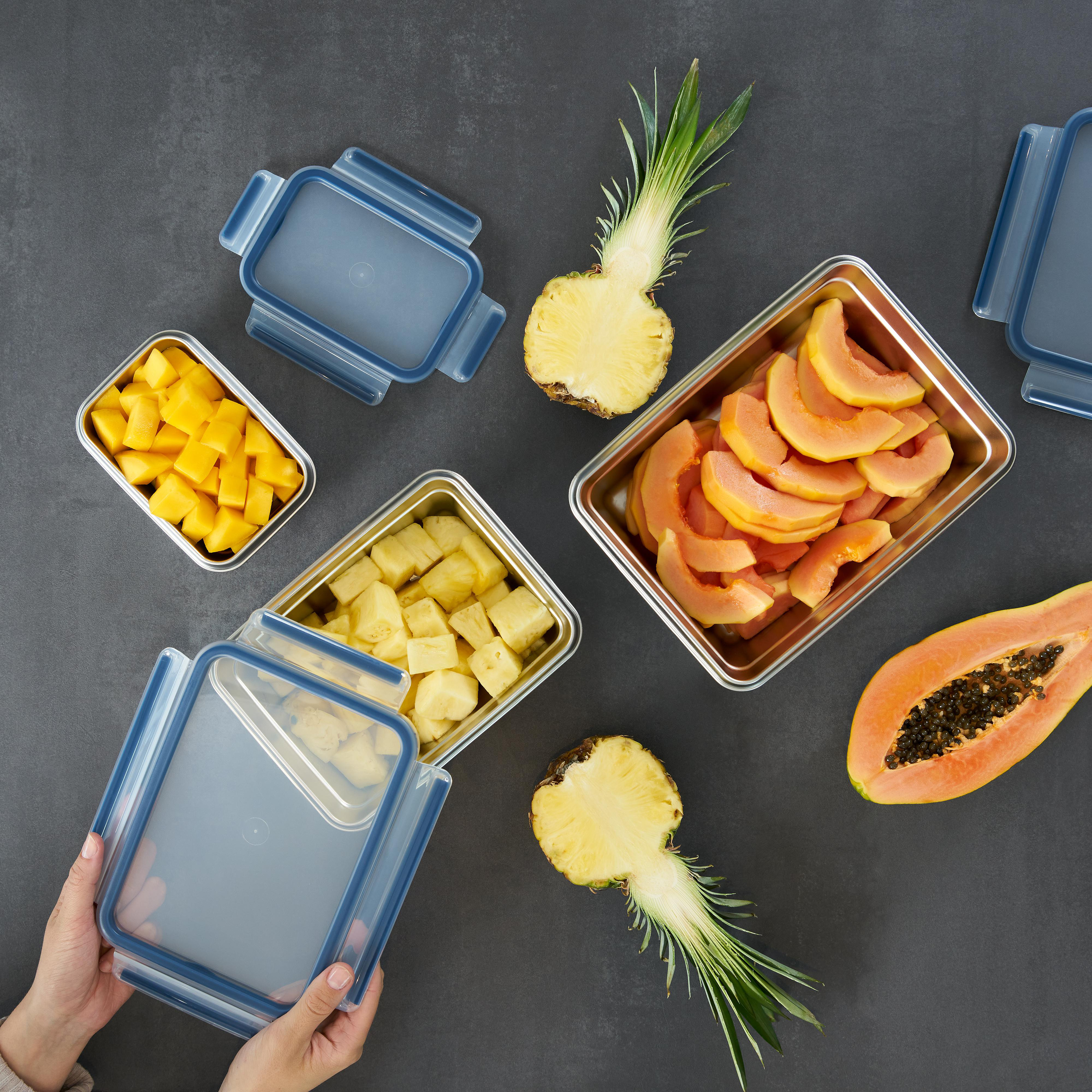 Draufsicht auf geschnittenes Obst in Behältern. Mango, Ananas und Papaya, in blauen Behältern.