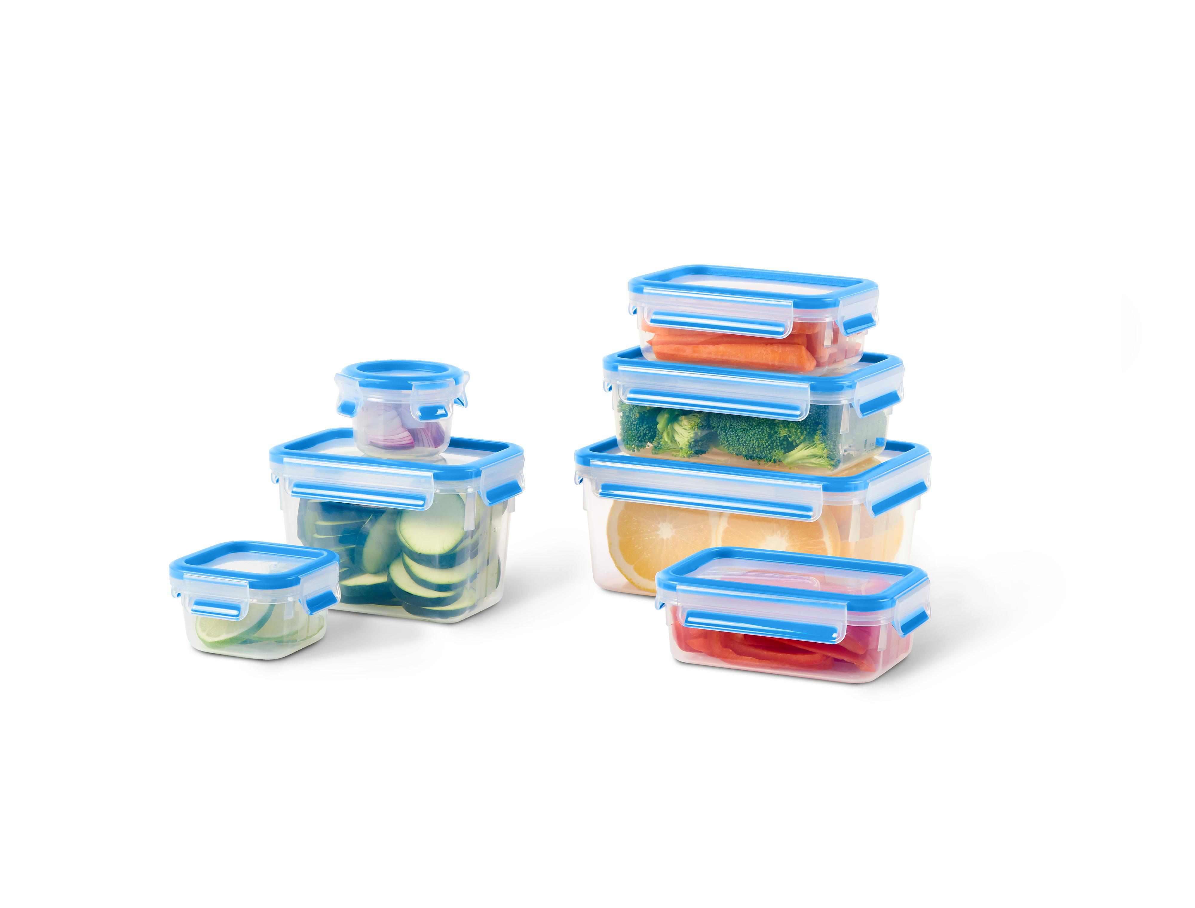 Plastik-Lebensmittelbehälter mit blauen Deckeln. Sie enthalten Gemüse und Obst.