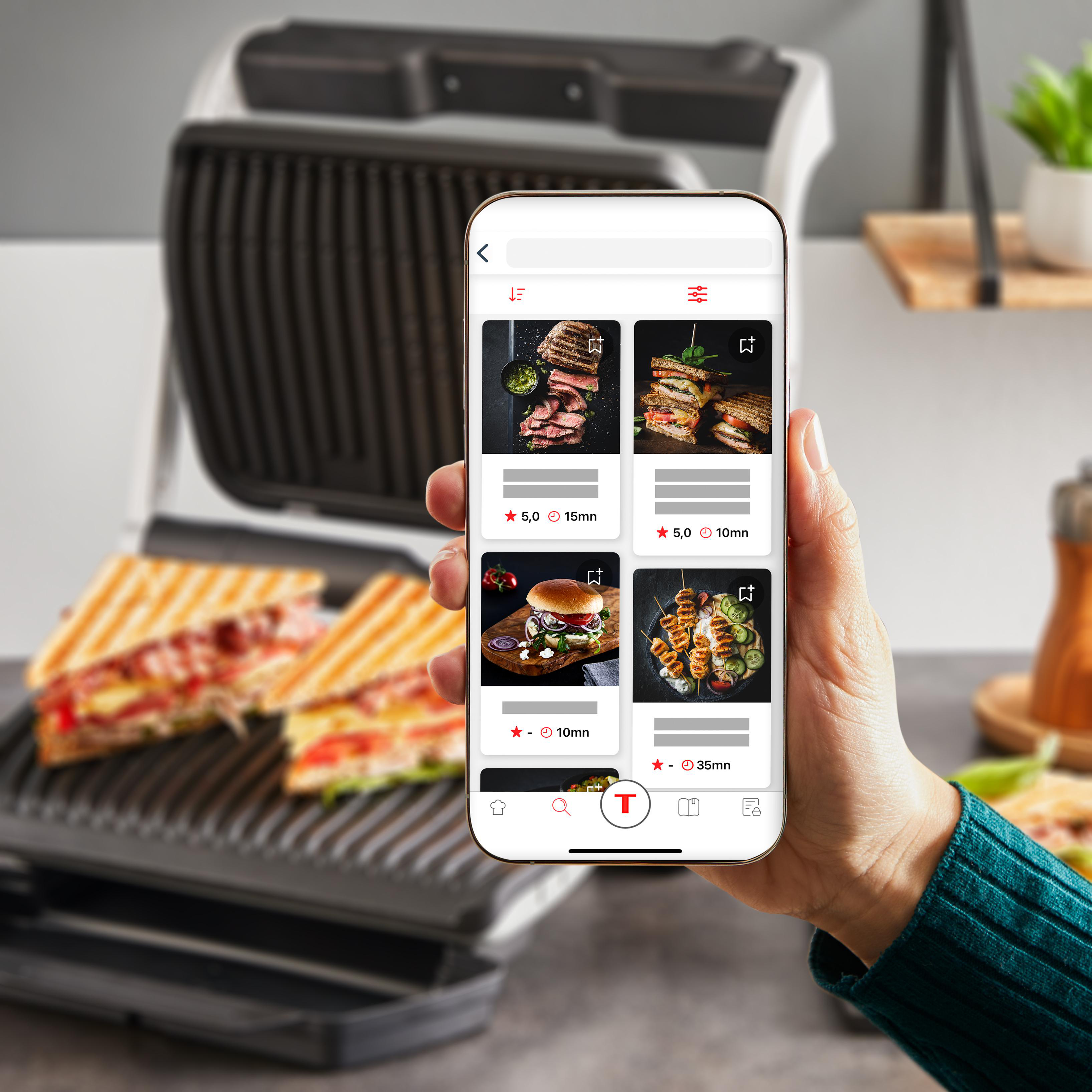 Hand, die ein Telefon hält, das eine Rezept-App mit Bildern verschiedener Lebensmittel zeigt.