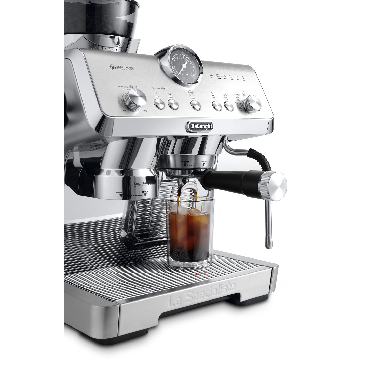 An espresso machine with a glass of coffee, a steam wand, and a pressure gauge.