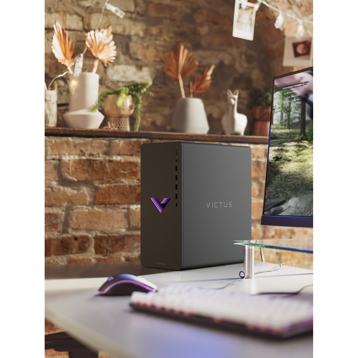 Een zwarte gaming desktop pc met paars licht staat op een witte desk, met een monitor en toetsenbord.