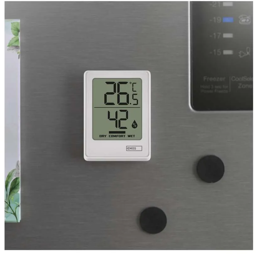 Digitális hőmérő 26,5°C-t, 42% páratartalmat mutat. Mágnesekkel egy hűtőszekrényen.