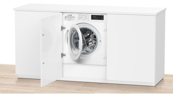 Una lavadora blanca instalada dentro de un armario blanco, con la puerta abierta.