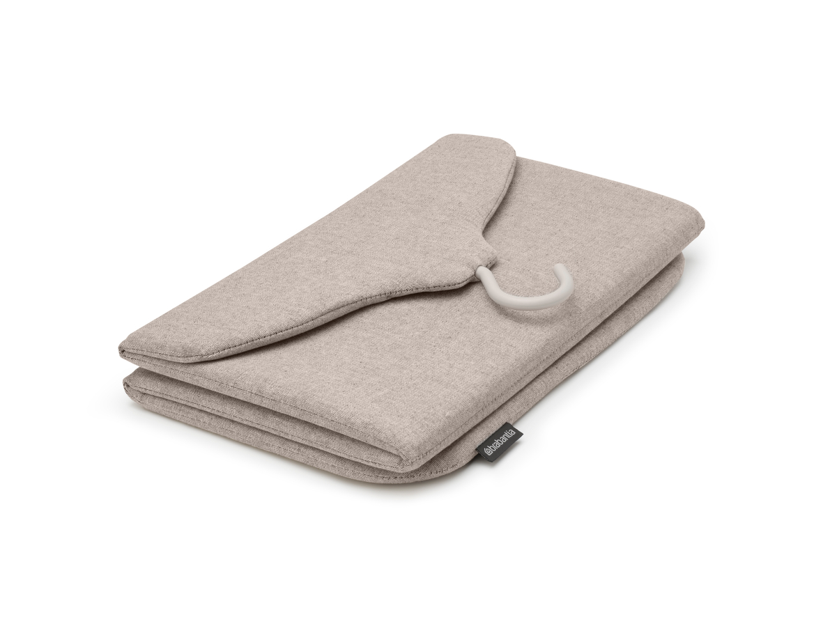 Gefaltete beige Kleiderschutzhülle mit einem weißen Kleiderbügel. Die Tasche ist geschlossen und liegt flach.