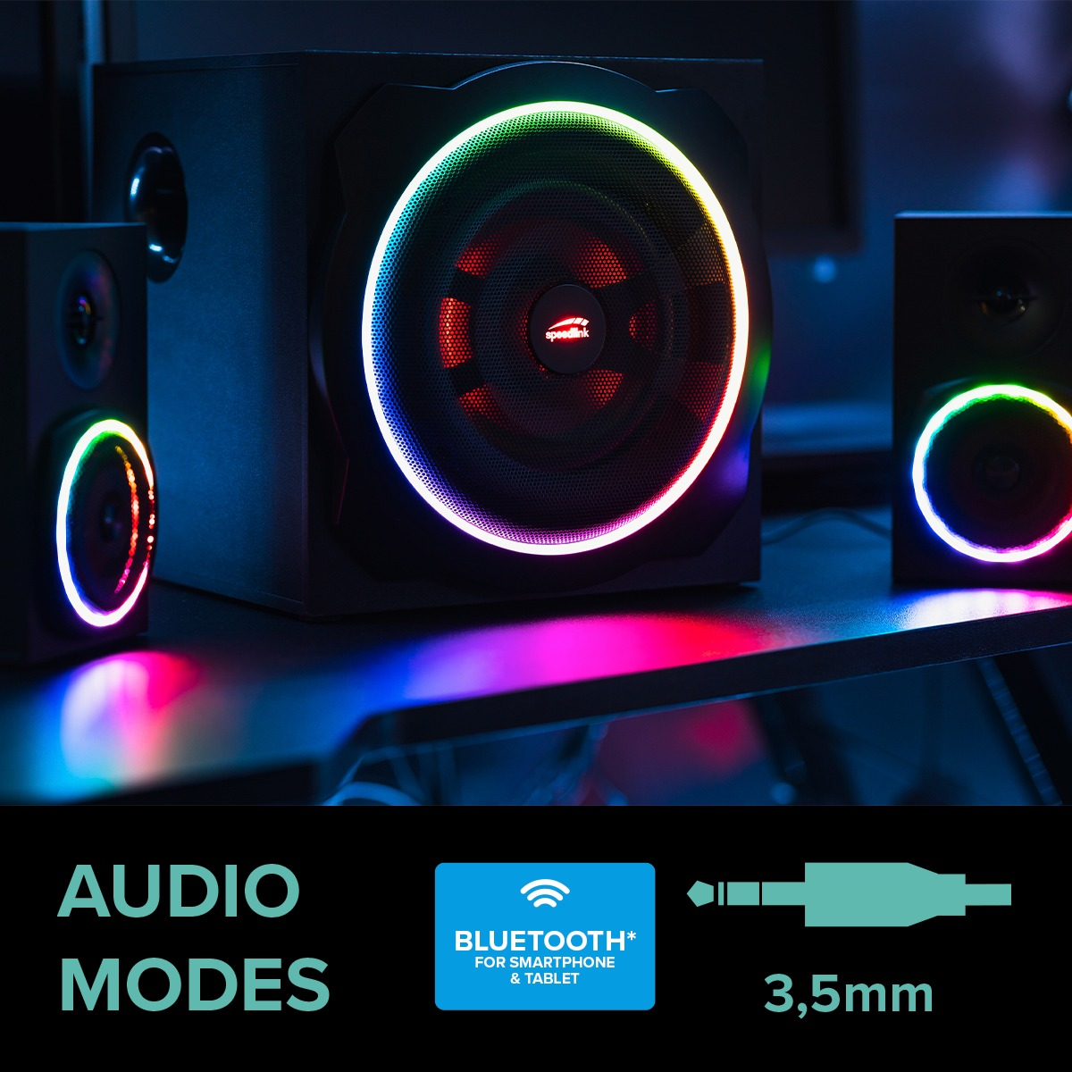 Schwarze Lautsprecher mit bunten LED-Ringen auf dunkler Oberfläche mit Audiomodus-Symbolen.