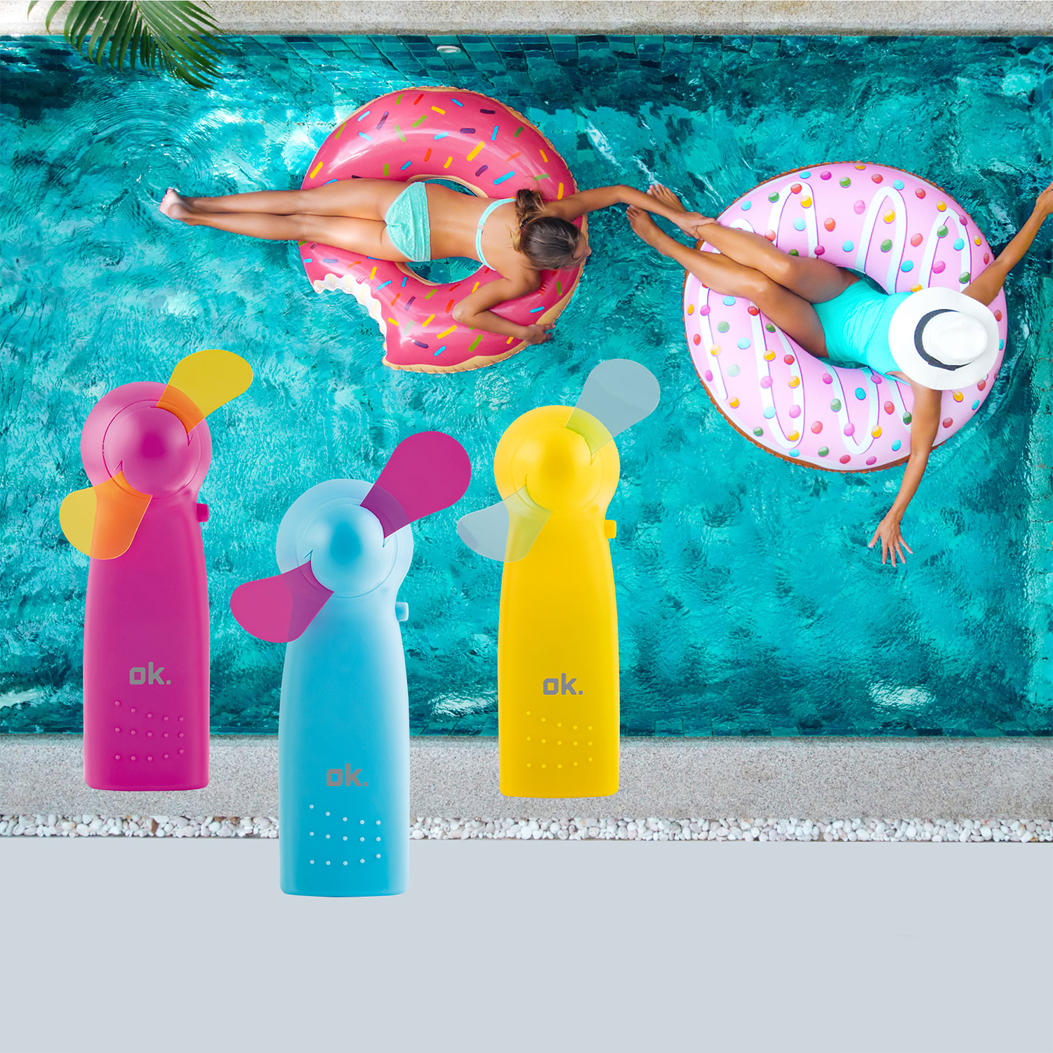 Tre mini ventilatori colorati e due persone su anelli gonfiabili in piscina. Vista dall'alto, colori vivaci, giornata di sole.