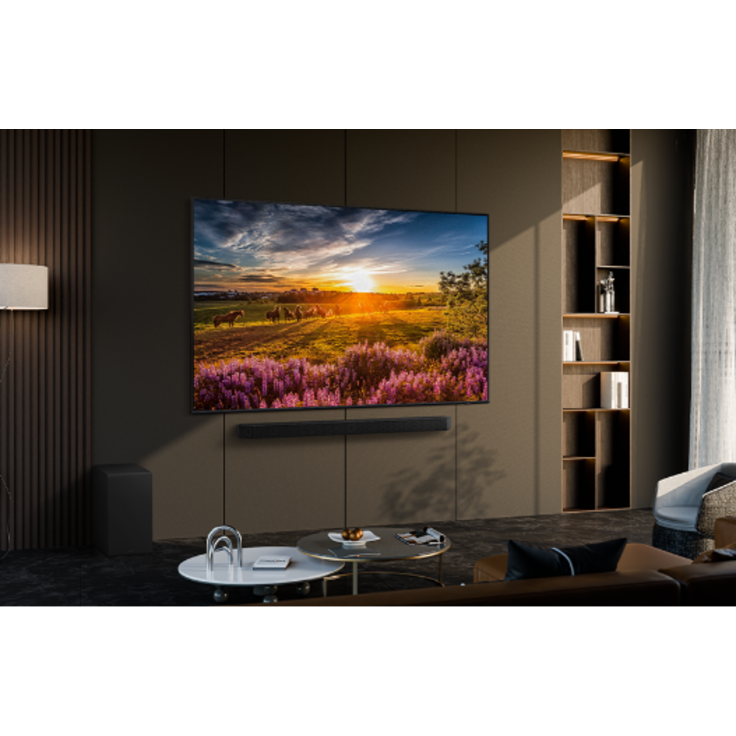 Een grote tv die een zonsondergang over een landschap toont. Een soundbar en een subwoofer staan eronder.