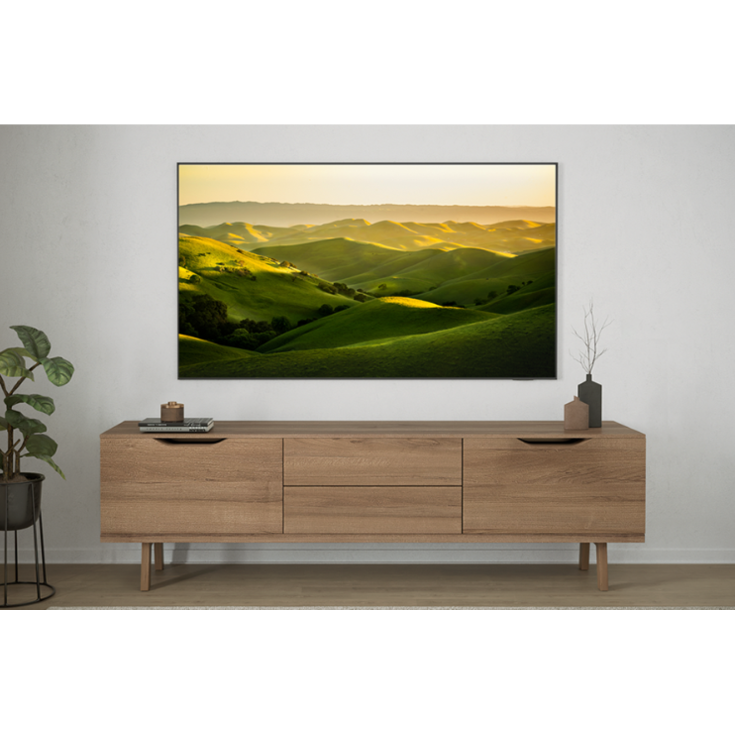 Een woonkamer met een houten kast en een groot tv-scherm met een groen landschap.