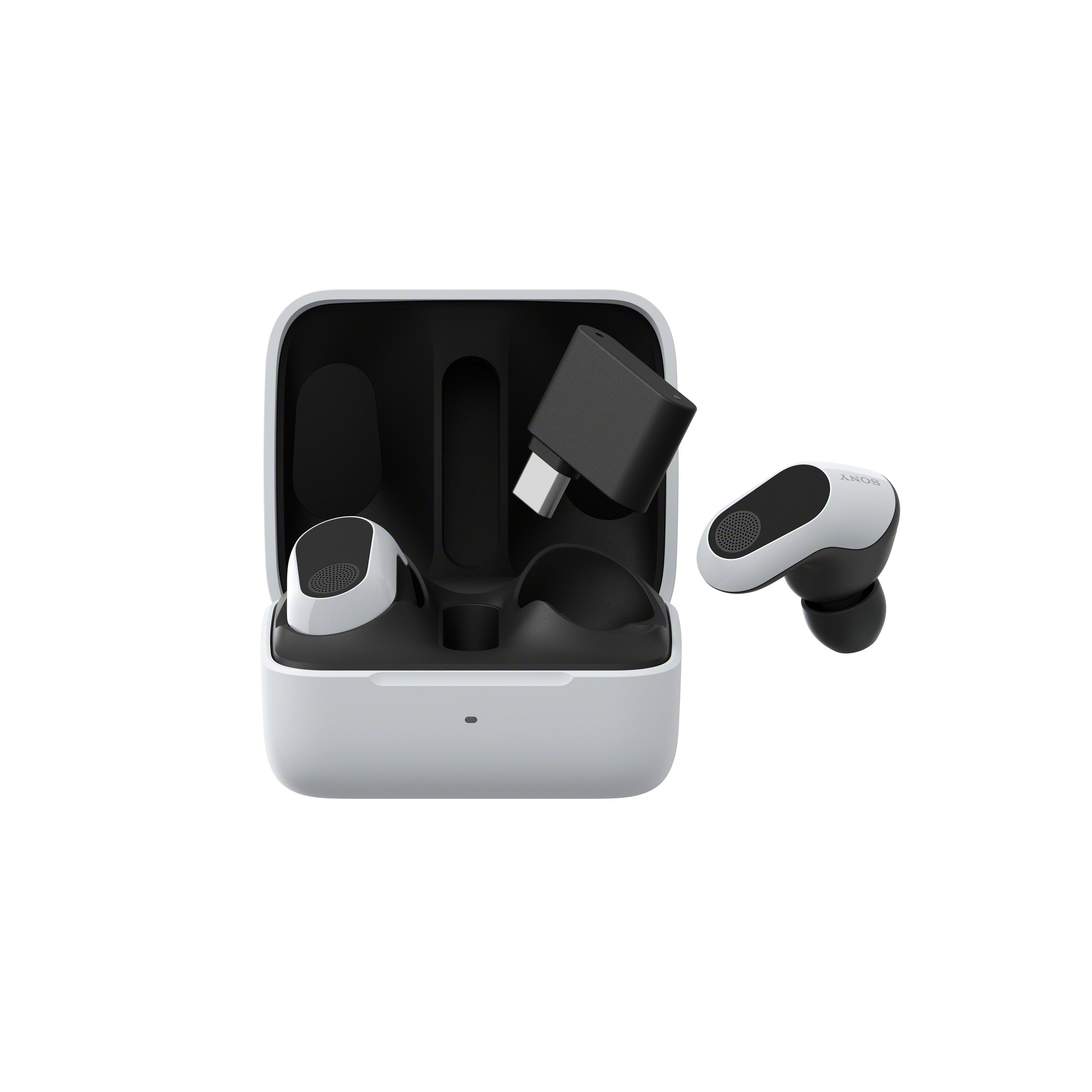 Auriculares inalámbricos blancos y negros en su estuche de carga, con un adaptador de carga.