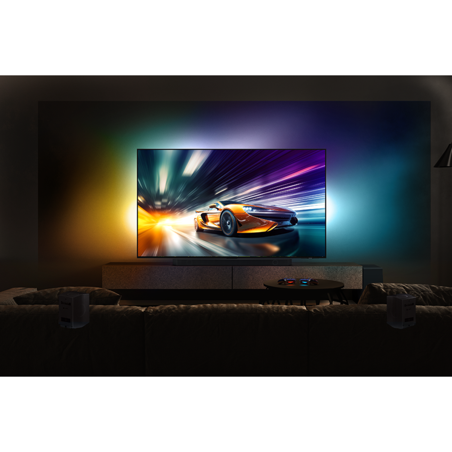 Een grote tv met een autorace. De tv heeft kleurrijke lichten. De bank staat ervoor.