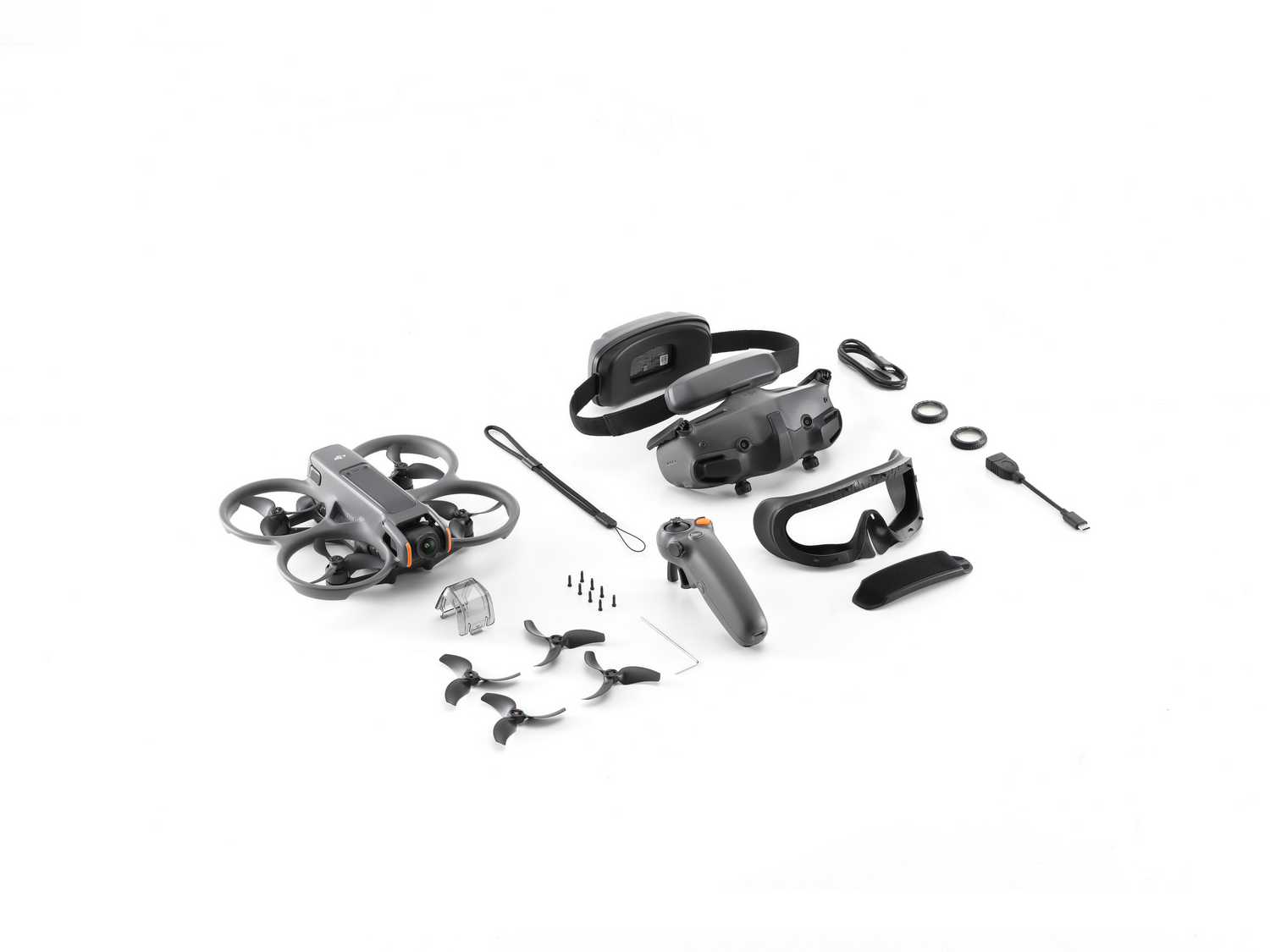 Piezas de dron. Dron, mando a distancia, gafas, cables y hélices adicionales sobre una superficie blanca.