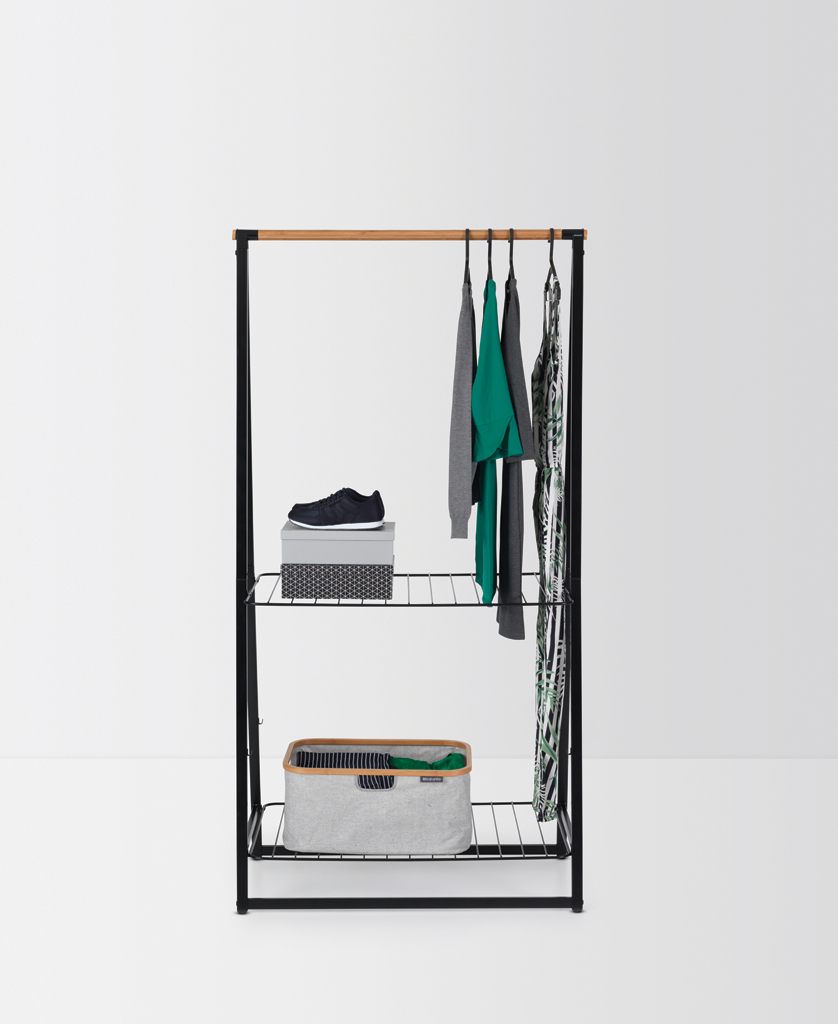 Kleiderständer mit Kleidung, Schuhen und Aufbewahrungsboxen auf weißem Hintergrund.