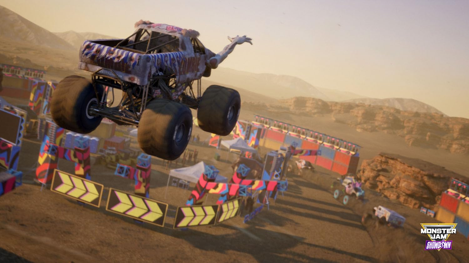 Monster truck en l'air au-dessus d'une course avec d'autres camions et des obstacles.