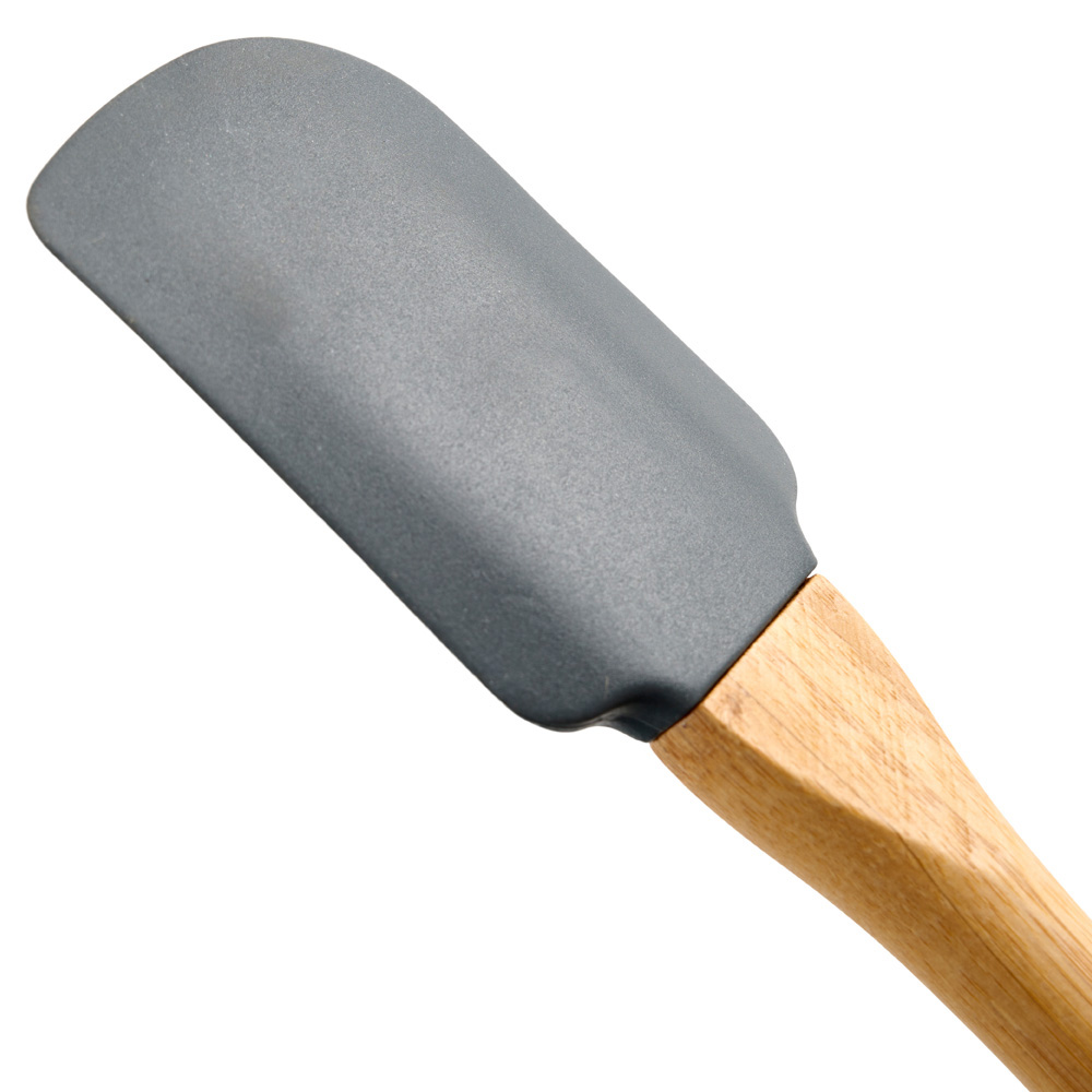 Espátula gris con mango de madera. La espátula está en ángulo.