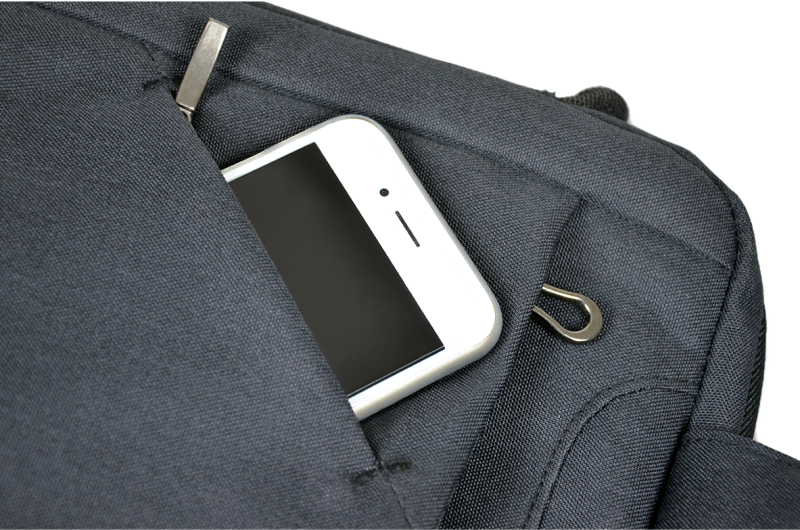 Ein weißes Smartphone ist teilweise in einer dunkelblauen Jackentasche zu sehen, Nahaufnahme.