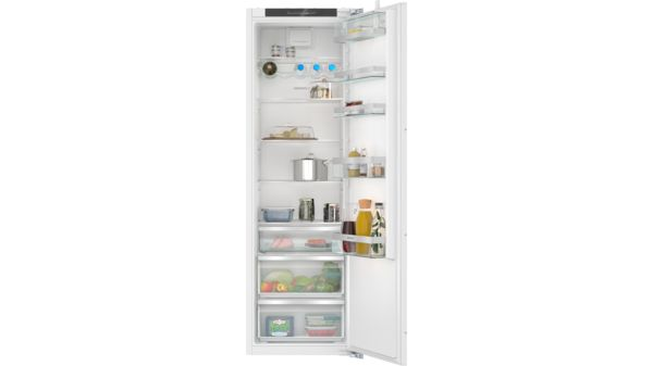 Refrigerador blanco abierto lleno de alimentos en estantes y cajones. Estantes de vidrio.
