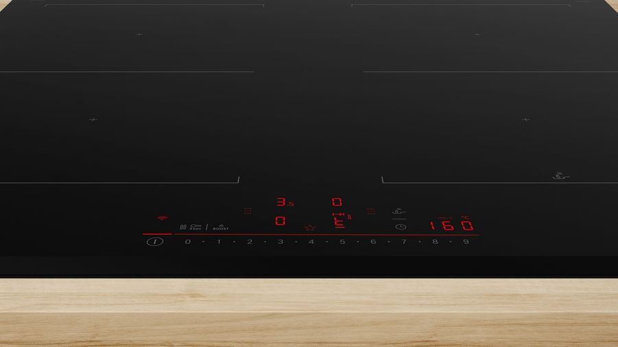 Placa de inducción negra con pantalla roja. Mostrando números.