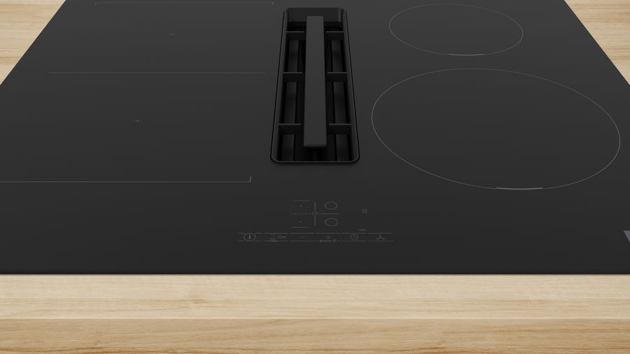 Encimera negra con ventilación integrada. Cuatro quemadores circulares y panel de control en madera clara.