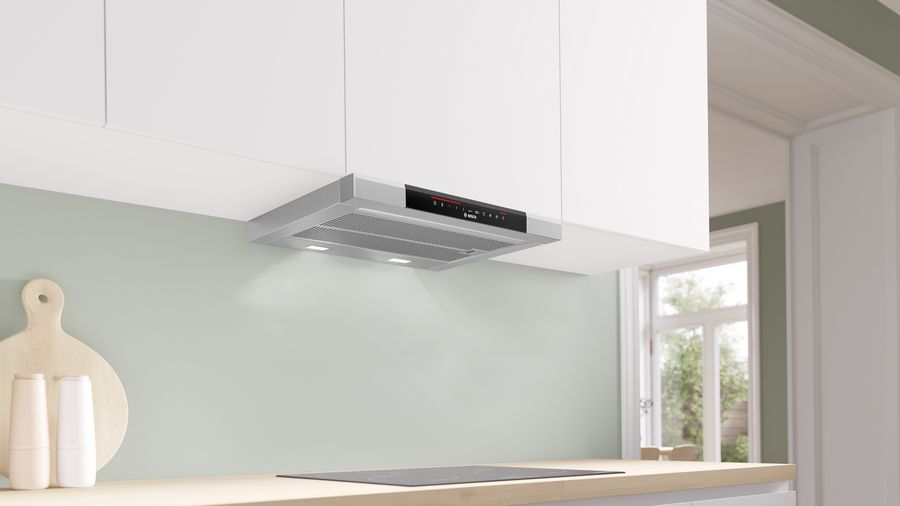 Una campana extractora de acero inoxidable instalada sobre una estufa en una cocina.