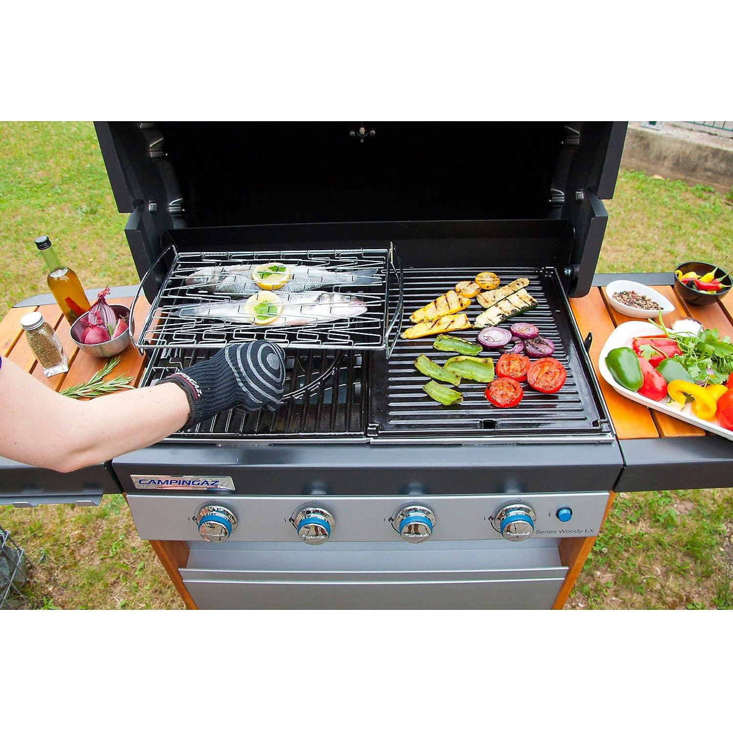 Un barbecue con cibo sopra, con una persona che griglia il cibo.