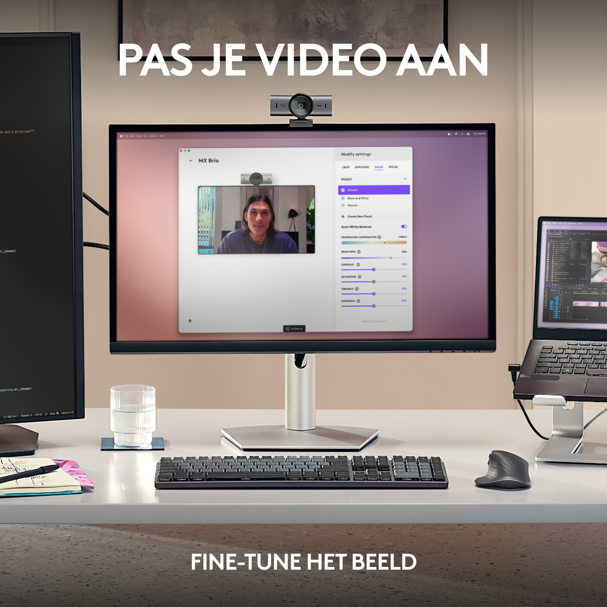 A monitor displays a man on a webcam, a keyboard, and a glass of water are on the desk.