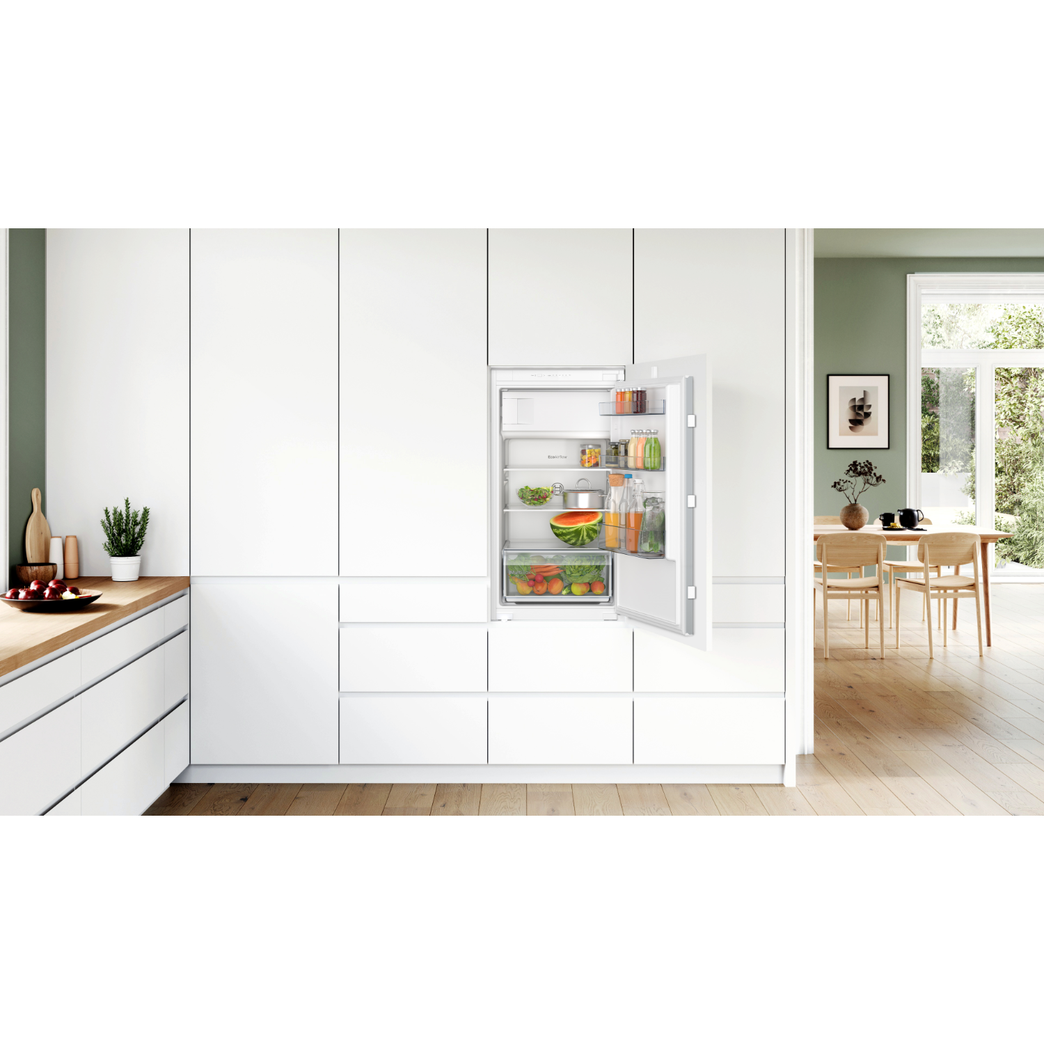 White kitchen with built-in refrigerator, open to show interior with food.