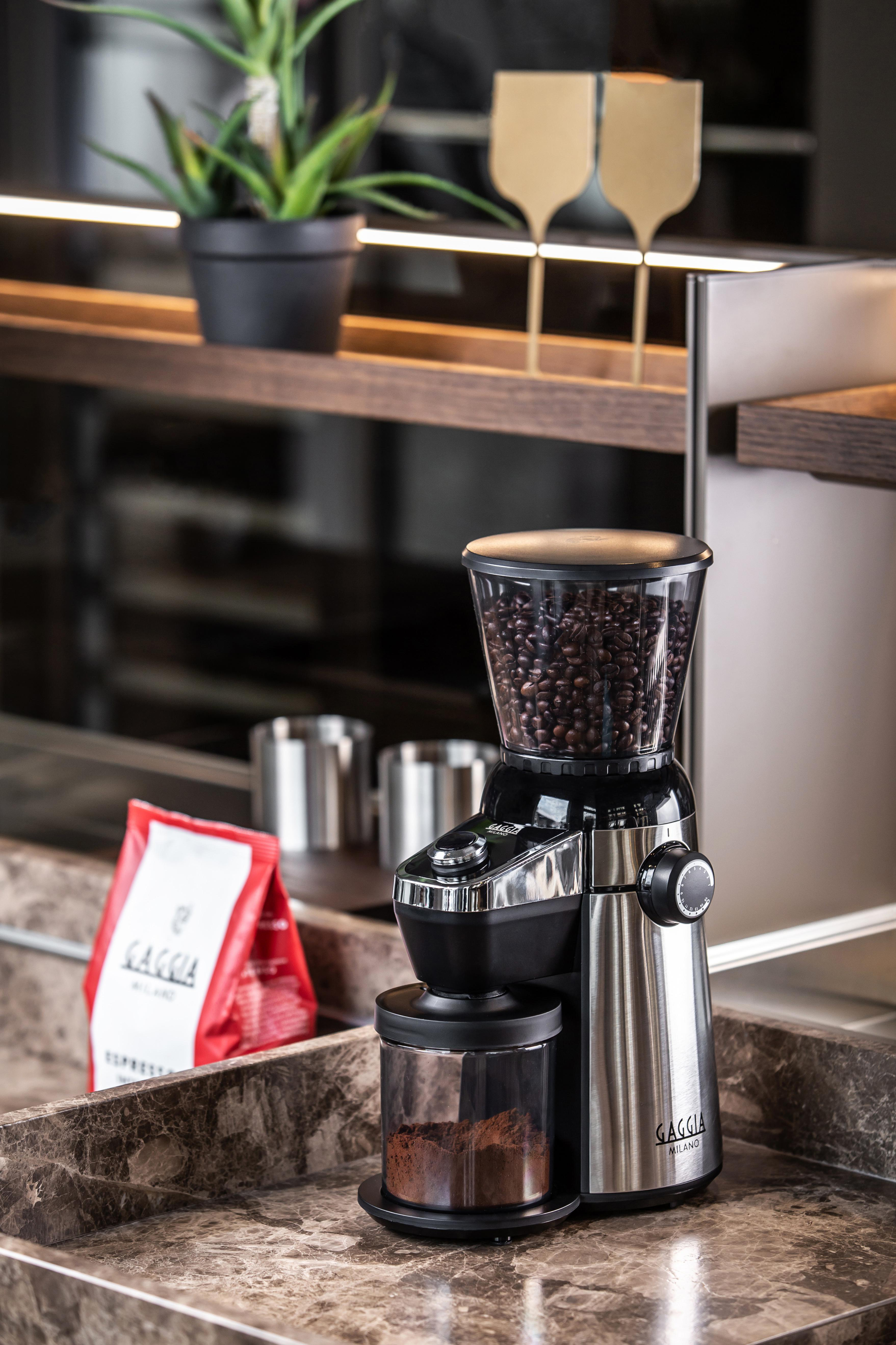 Kaffeemühle mit Kaffeebohnen, gemahlenem Kaffee und einer Kaffeetüte.
