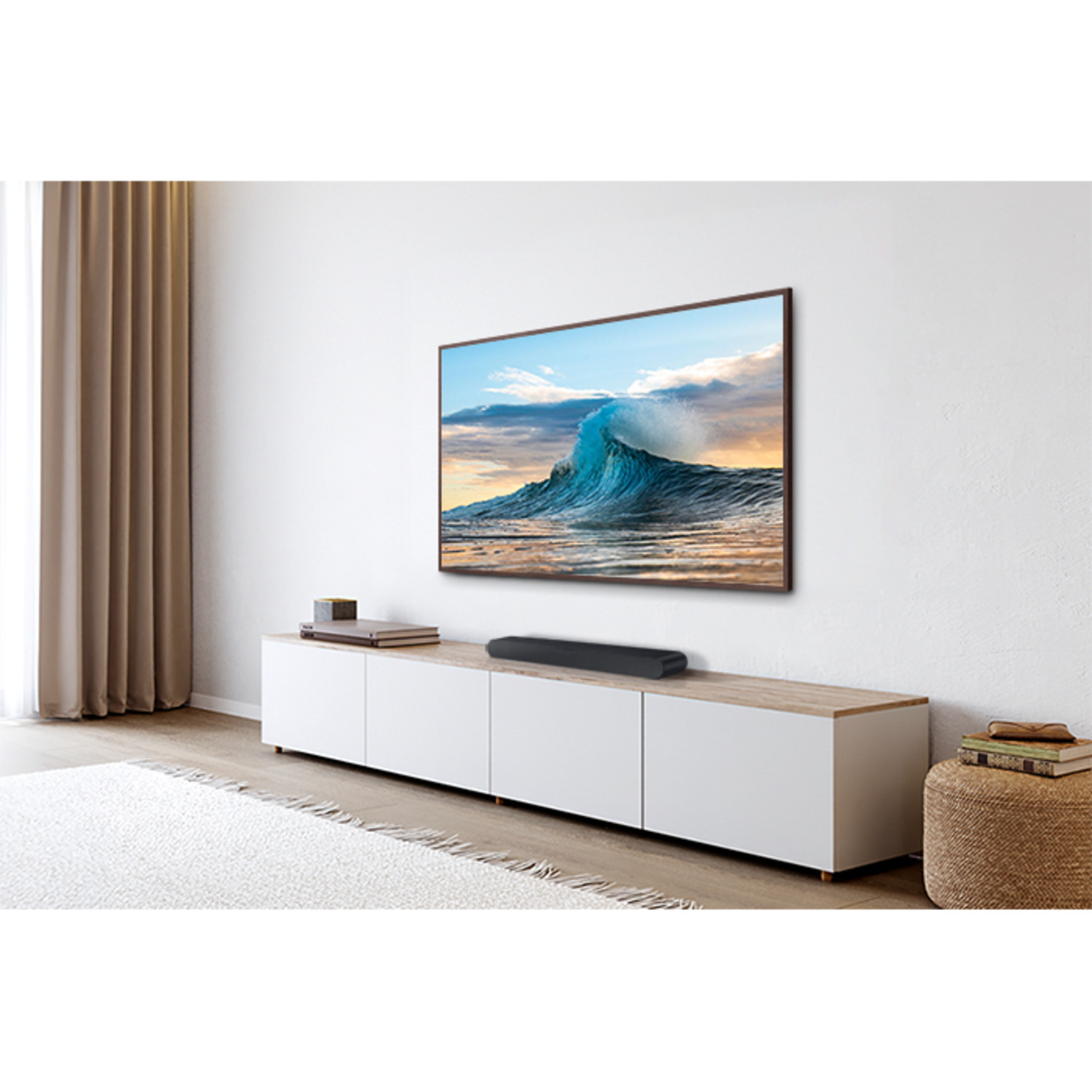 TV displaying ocean scene, soundbar under, on a white cabinet, with white walls.