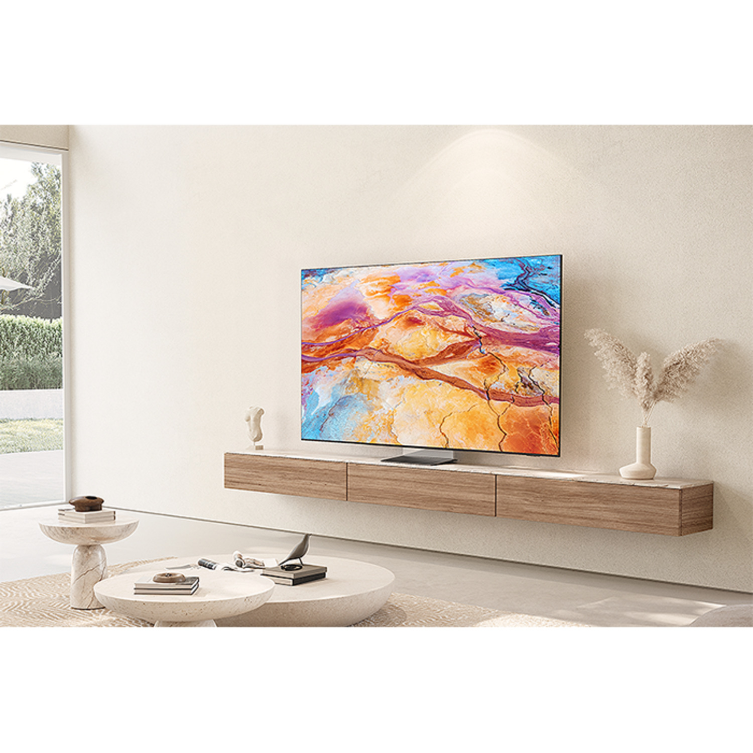 Woonkamer met tv aan de muur, bank en decor. Tv toont kleurrijke abstracte kunst. Beige en witte tinten.