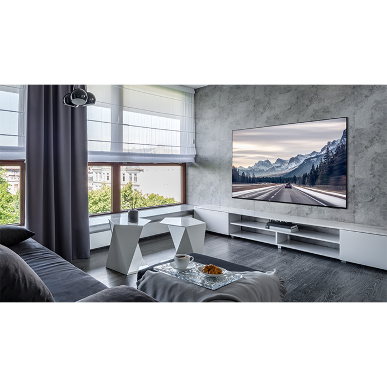 Woonkamer met tv, bergweg, bank, ramen en decoratie.