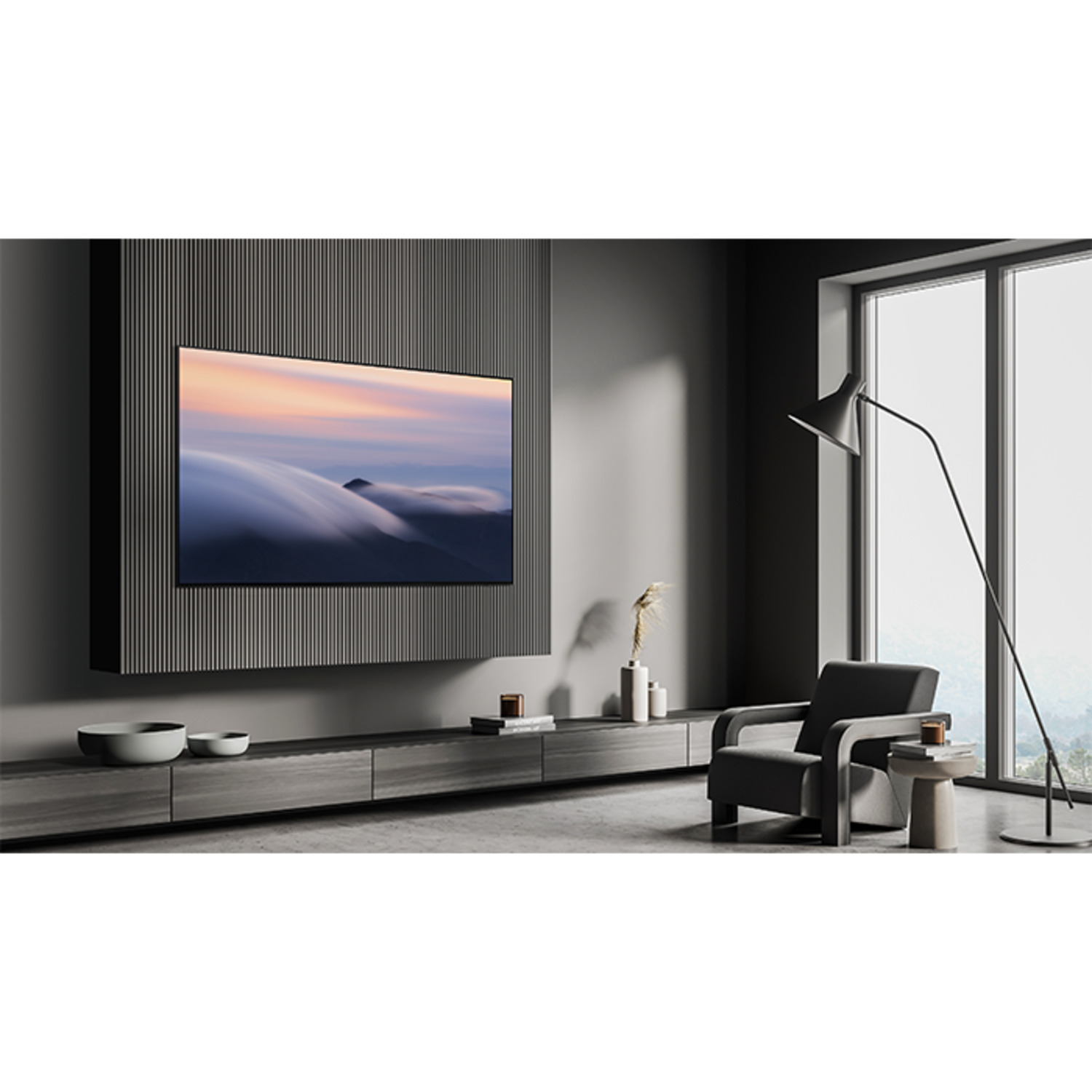 Woonkamer met een tv aan de muur. Er zijn een bank, stoel en lamp aanwezig.