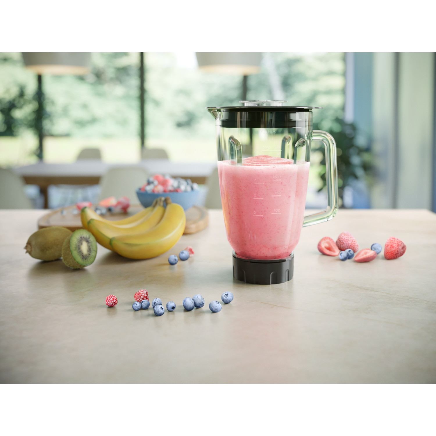 Blender met roze smoothie en fruit op een tafel. Bessen en bananen zichtbaar.
