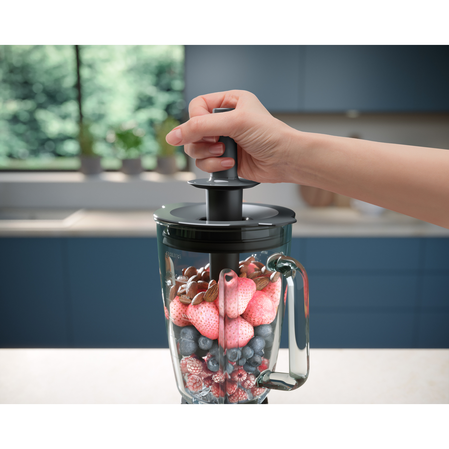 Hand houdt een deksel vast, voegt fruit en noten toe in een blender.