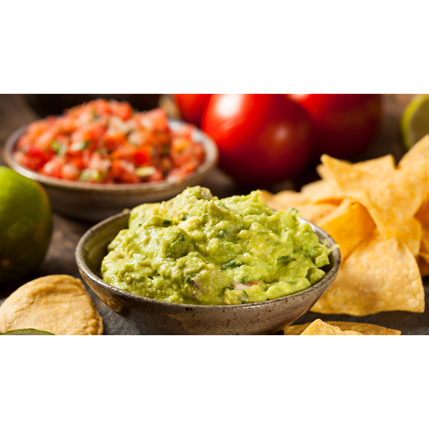 Kom met guacamole, salsa, chips en tomaten.