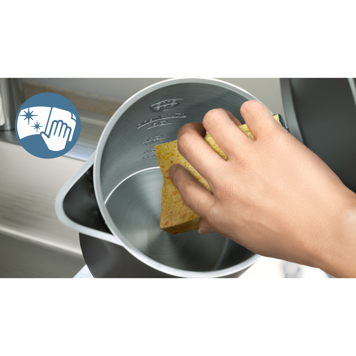 Een persoon maakt de binnenkant van een waterkoker schoon met een spons. Een hand houdt de spons vast.