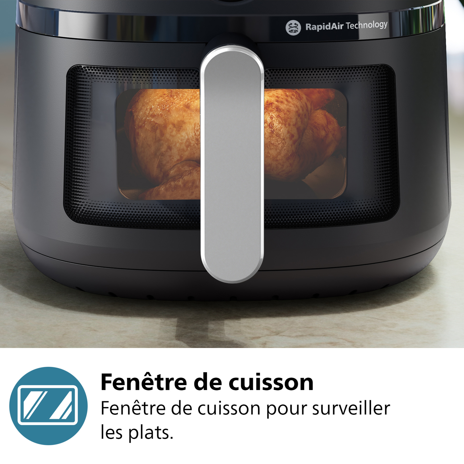 Friteuse à air Philips noire avec poulet à l'intérieur. Fenêtre de cuisson visible.