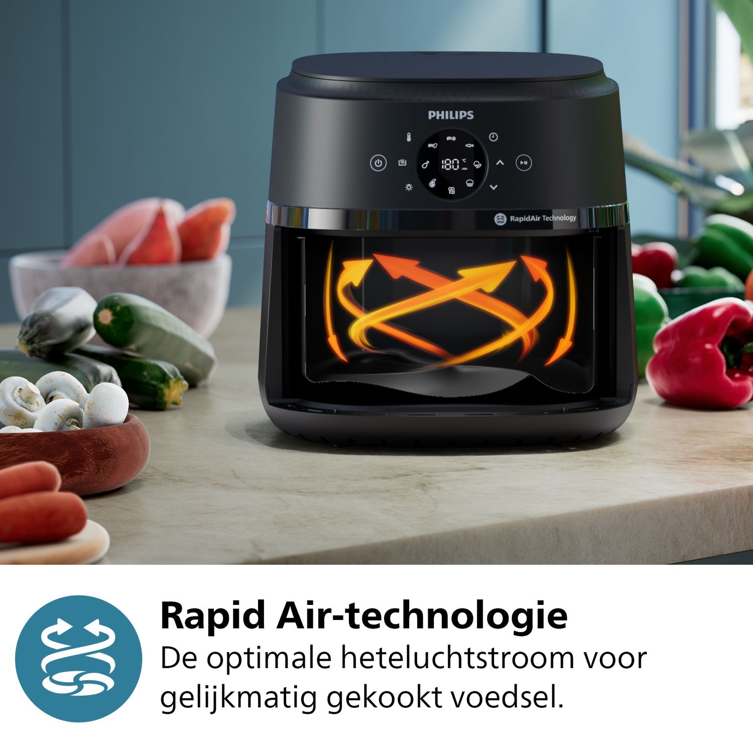 Zwarte airfryer met oranje pijlen, op een aanrecht met groenten.