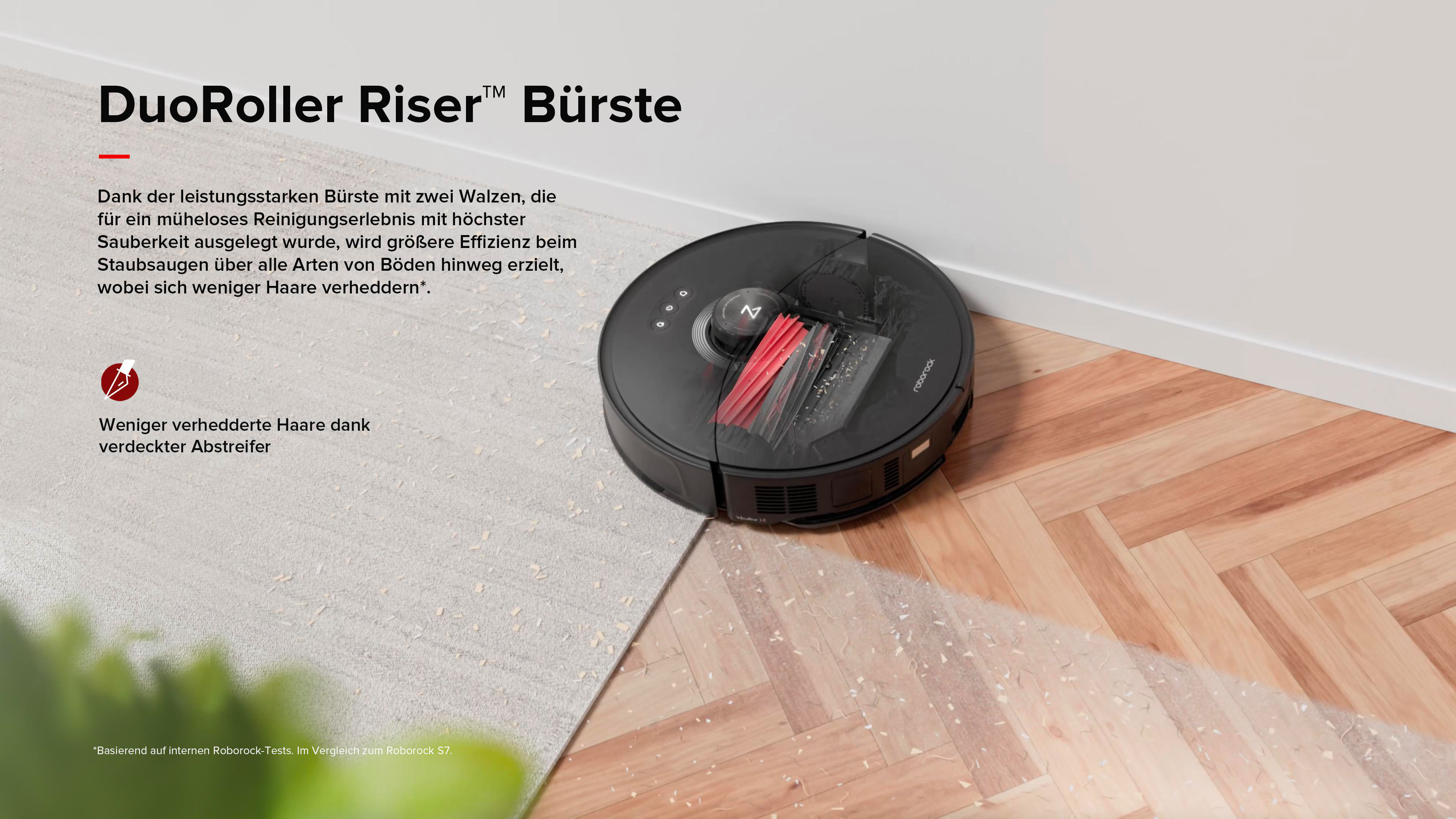 Ein Roboter-Staubsauger reinigt einen Boden, in der Nähe eines Teppichs und eines Holzbodens.