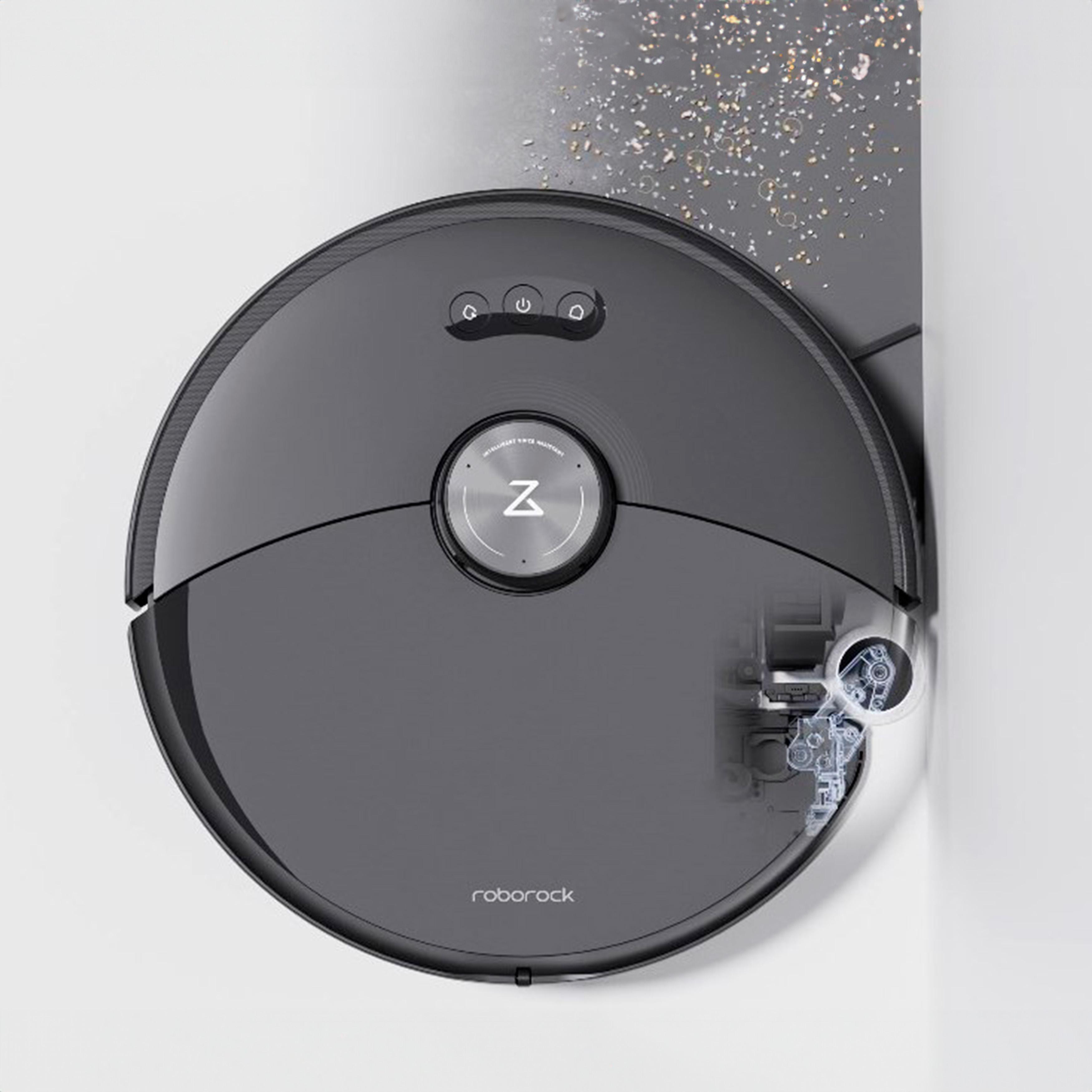 Ein dunkelgrauer Roboter-Staubsauger auf einer weißen Oberfläche, mit sichtbaren Innenteilen des Roboters.
