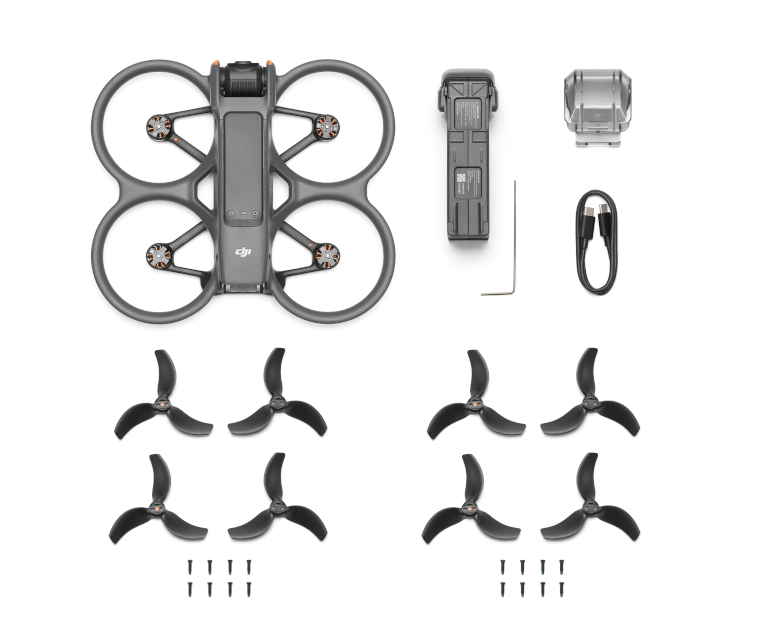 Dron i akcesoria na białej powierzchni. Śmigła, bateria, ładowarka i więcej.