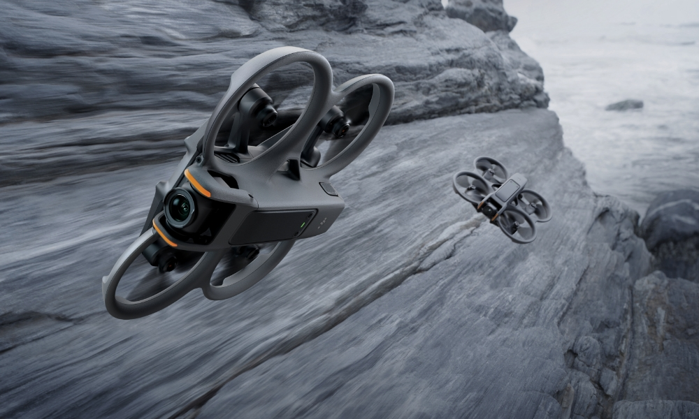 Dwa drony lecące nad skałami. Jeden jest w oddali. Niebo jest zachmurzone.