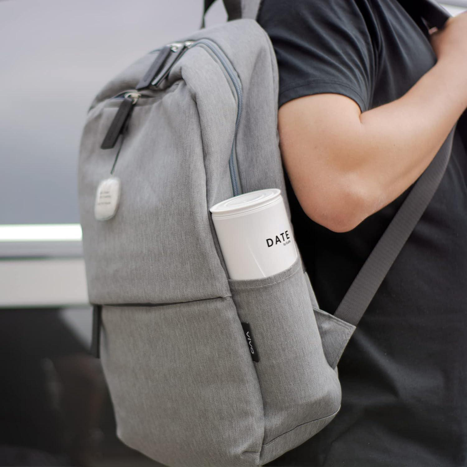 Person mit grauem Rucksack und weißem Behälter in der Seitentasche.