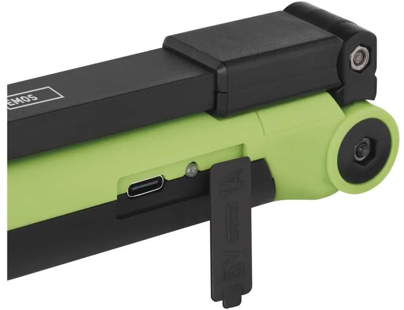 Egy zöld és fekete zseblámpa USB porttal és nyitott töltőport fedéllel.