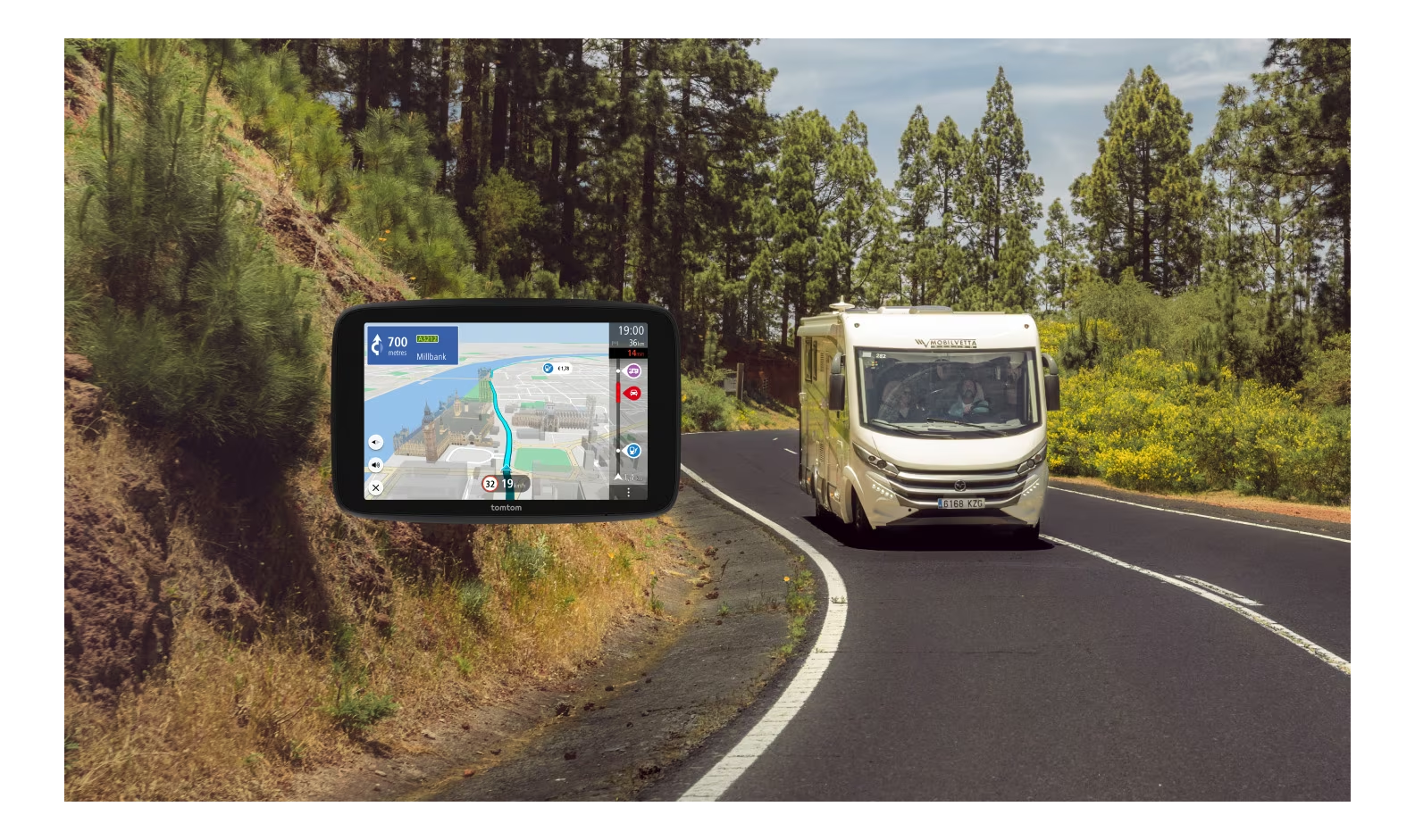 GPS-Bildschirm auf Straße mit Wohnmobil und Wald im Hintergrund.