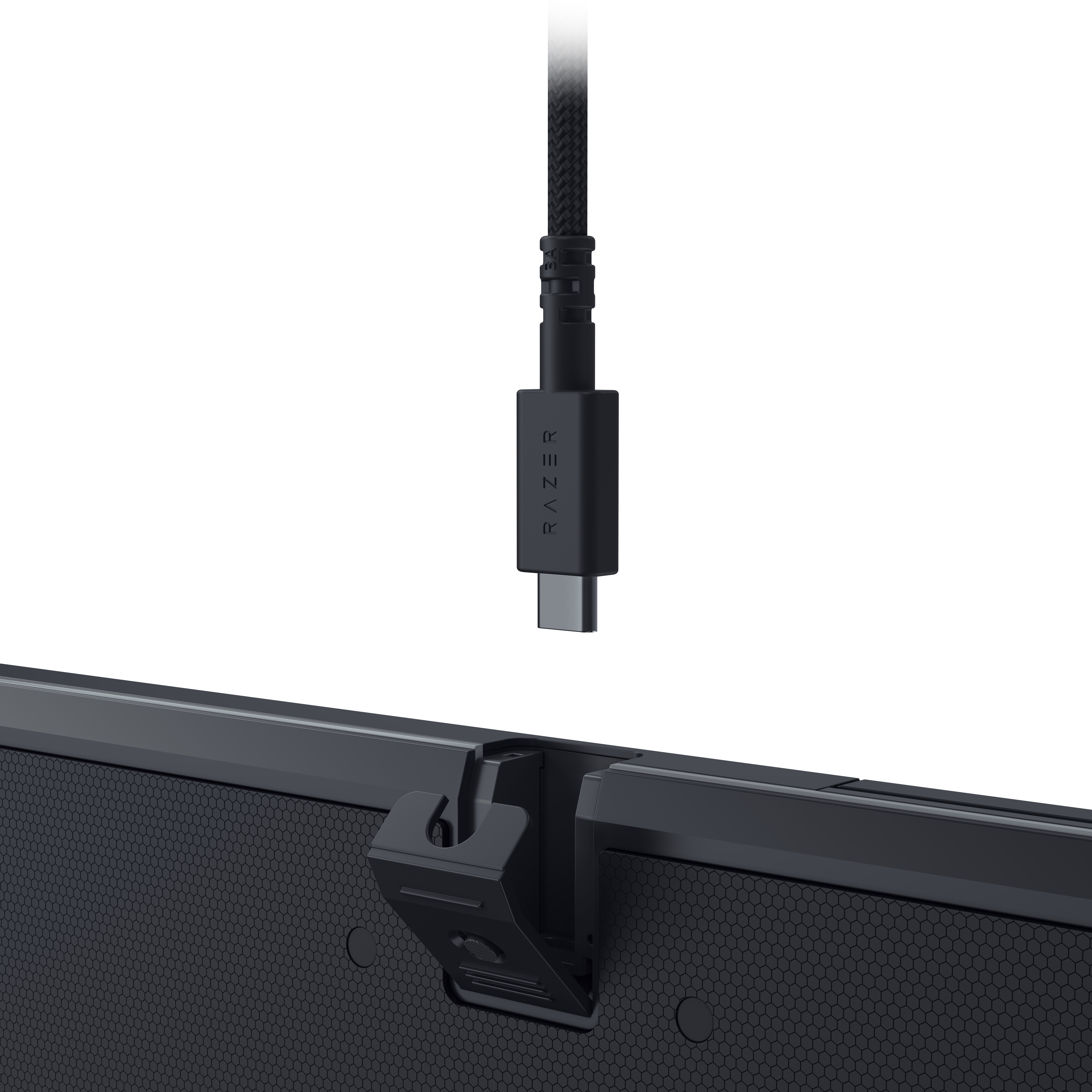Ein schwarzes USB-C-Kabel, das in die Rückseite einer schwarzen Tastatur eingesteckt ist.