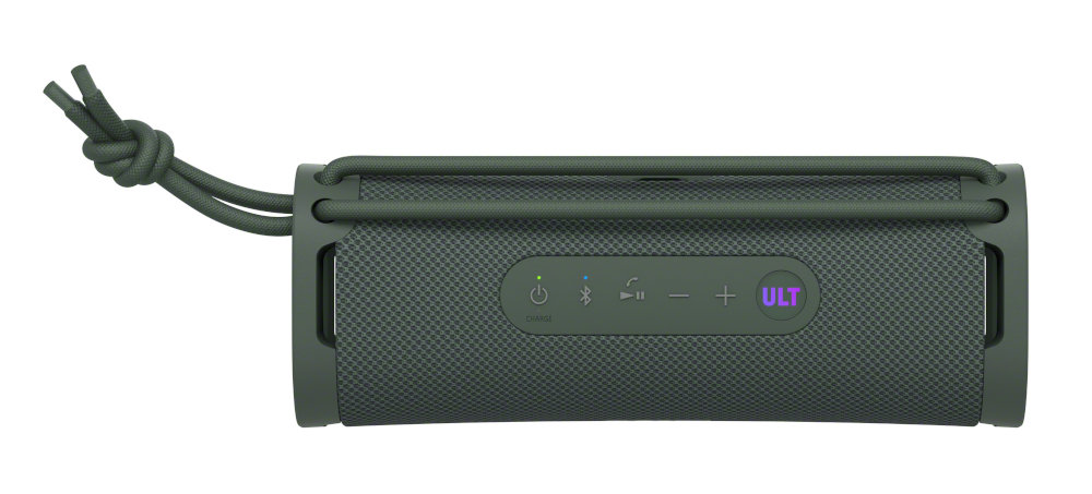 Ciemnozielony głośnik z przyciskami sterowania. Głośnik ma sznurek. Białe tło.