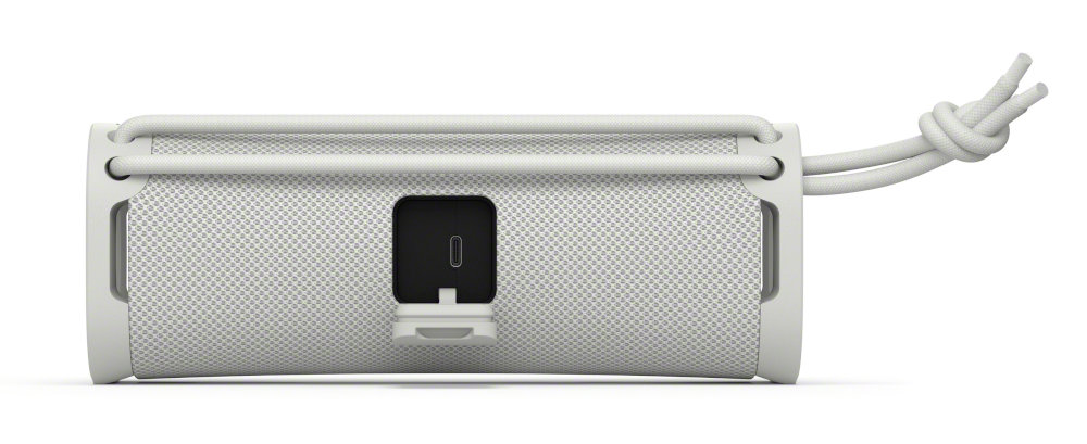 Laptop, zamknięty, pokazujący profil boczny, w ciemnym otoczeniu.