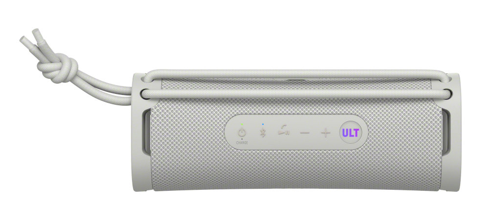 Biały prostokątny głośnik z przyciskami i zawiązanym sznurkiem. Ma siatkową powierzchnię i słowo 'ULT'.